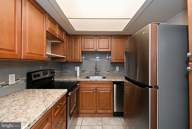 a kitchen with a sink a refrigerator and cabinets