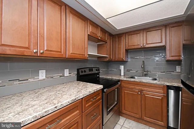 a kitchen with stainless steel appliances granite countertop a sink stove and cabinets