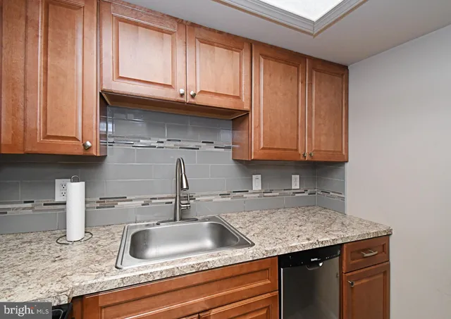 a kitchen with granite countertop a sink and cabinets