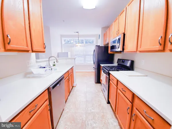 a kitchen with stainless steel appliances a sink and a large window