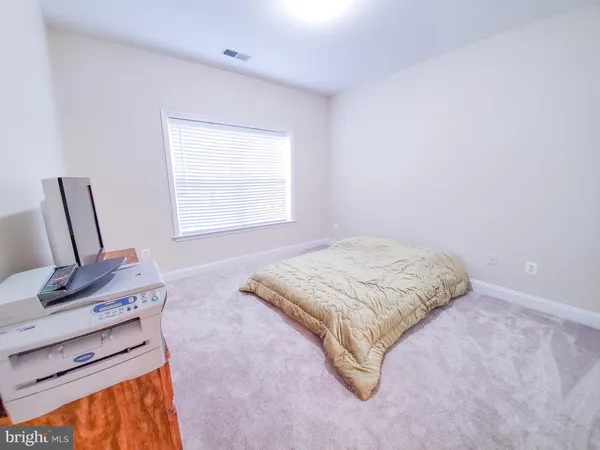 a bedroom with a bed window and chair