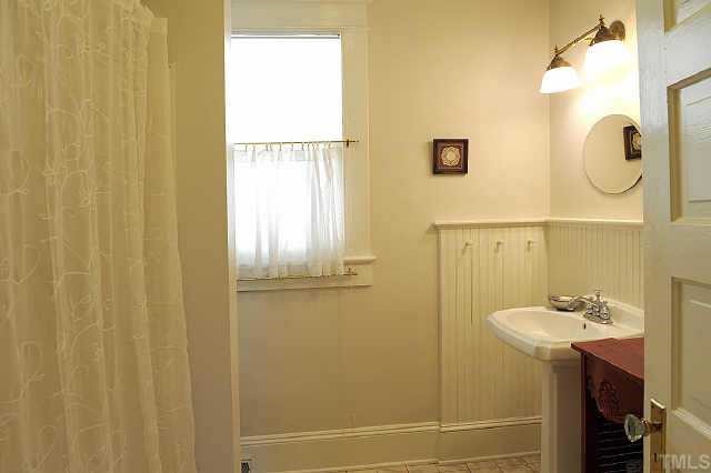 1707 Dare Street Raleigh, NC 27608 - Photo 11 of 12 Bead board wainscotting adds classic charm to the second bath.