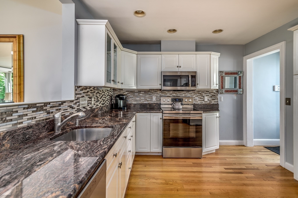56 Radcliffe Road Belmont, MA 02478 - Photo 11 of 41 a kitchen with kitchen island granite countertop a stove sink microwave and cabinets