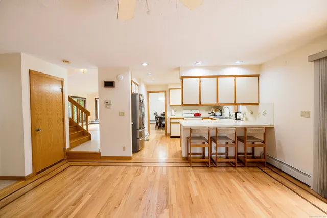 a living room with stainless steel appliances kitchen island granite countertop furniture and a wooden floor