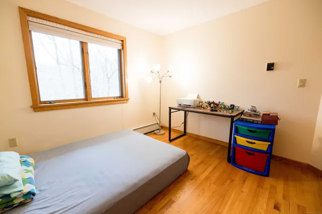 a bedroom with a bed and wooden floor