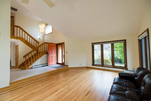 a view of a livingroom with wooden floor and stairs