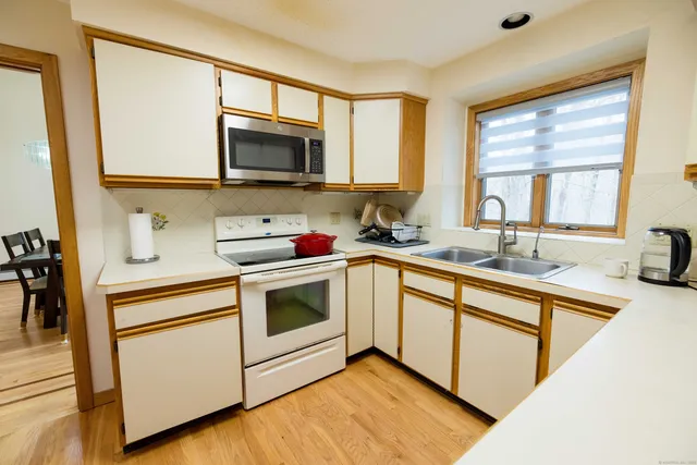 a kitchen with stainless steel appliances a stove microwave and sink