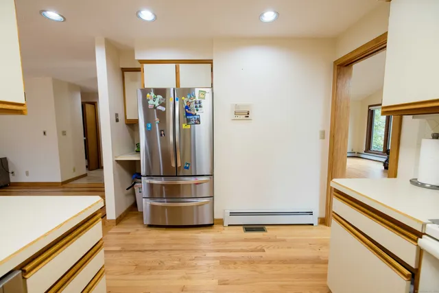 a view of kitchen with stainless steel appliances granite countertop a refrigerator and a stove top oven