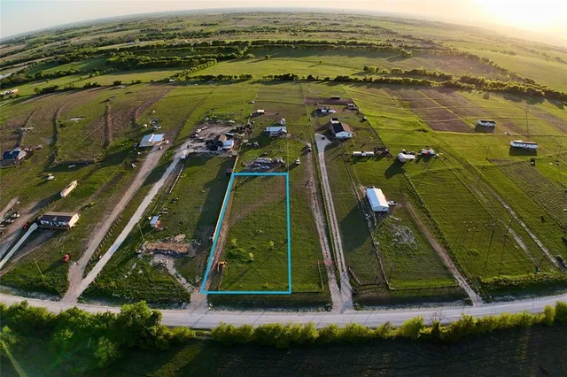 an aerial view of a residential houses with outdoor space and trees