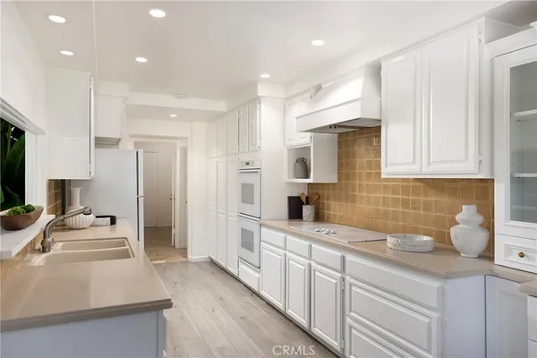 a kitchen with granite countertop a sink stainless steel appliances and cabinets