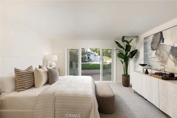 a bedroom with a large bed and a potted plant