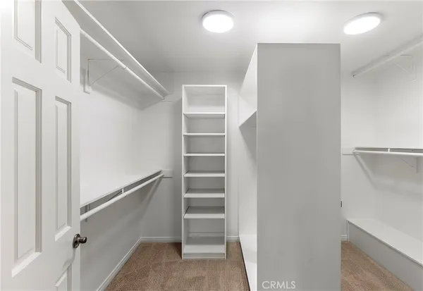 a view of walk in closet with empty racks