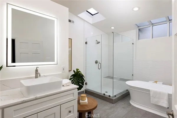 a bathroom with a tub a sink and mirror