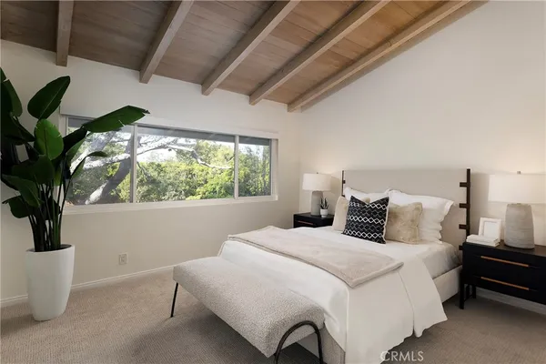 a bedroom with a large bed and a potted plant