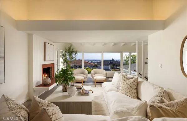 a living room with furniture a fireplace and a large window