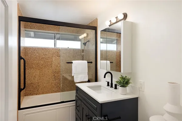 a bathroom with a sink a mirror and a shower