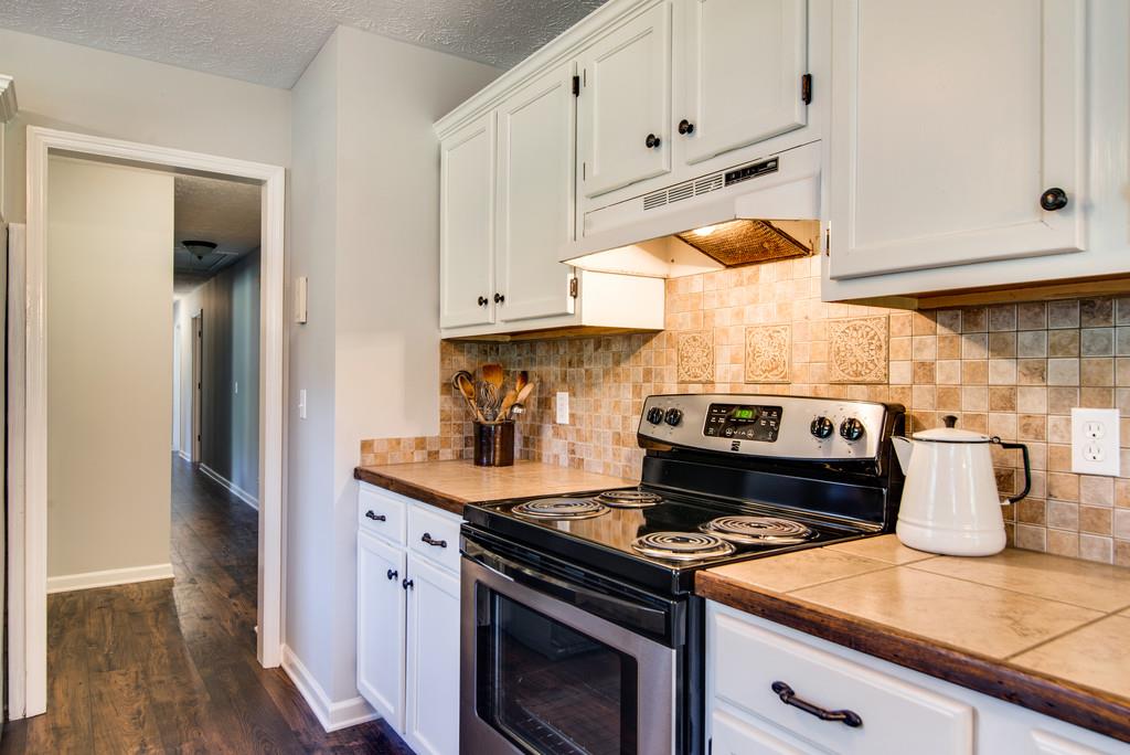 7315 Coldwater Road Fairview, TN 37062 - Photo 8 of 30 a kitchen with a stove and white cabinets