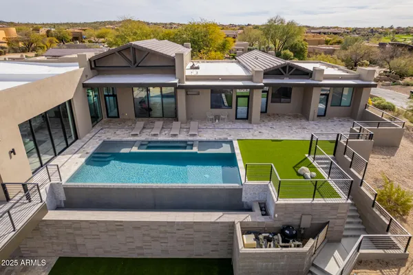 an aerial view of a house with a mountain