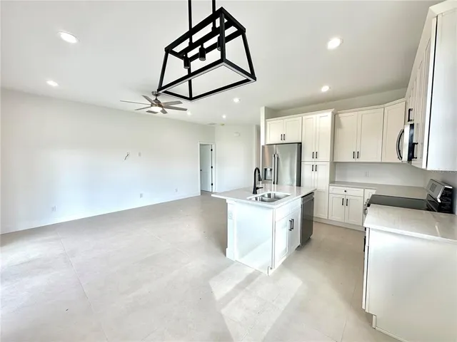 a large kitchen with kitchen island a stove a sink dishwasher and a refrigerator