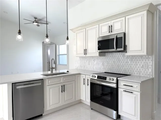 a kitchen with cabinets stainless steel appliances and a sink