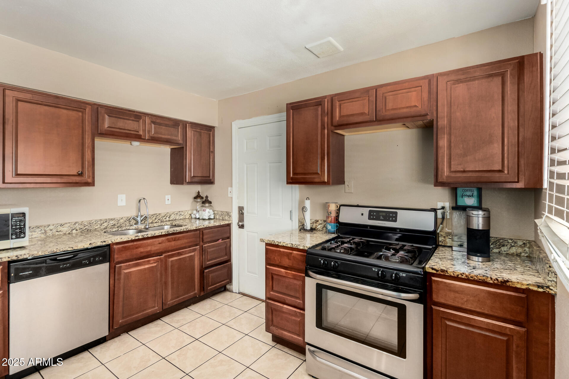 3152 North 24th Drive Phoenix, AZ 85015 - Photo 12 of 28 a kitchen with granite countertop a stove sink and cabinets