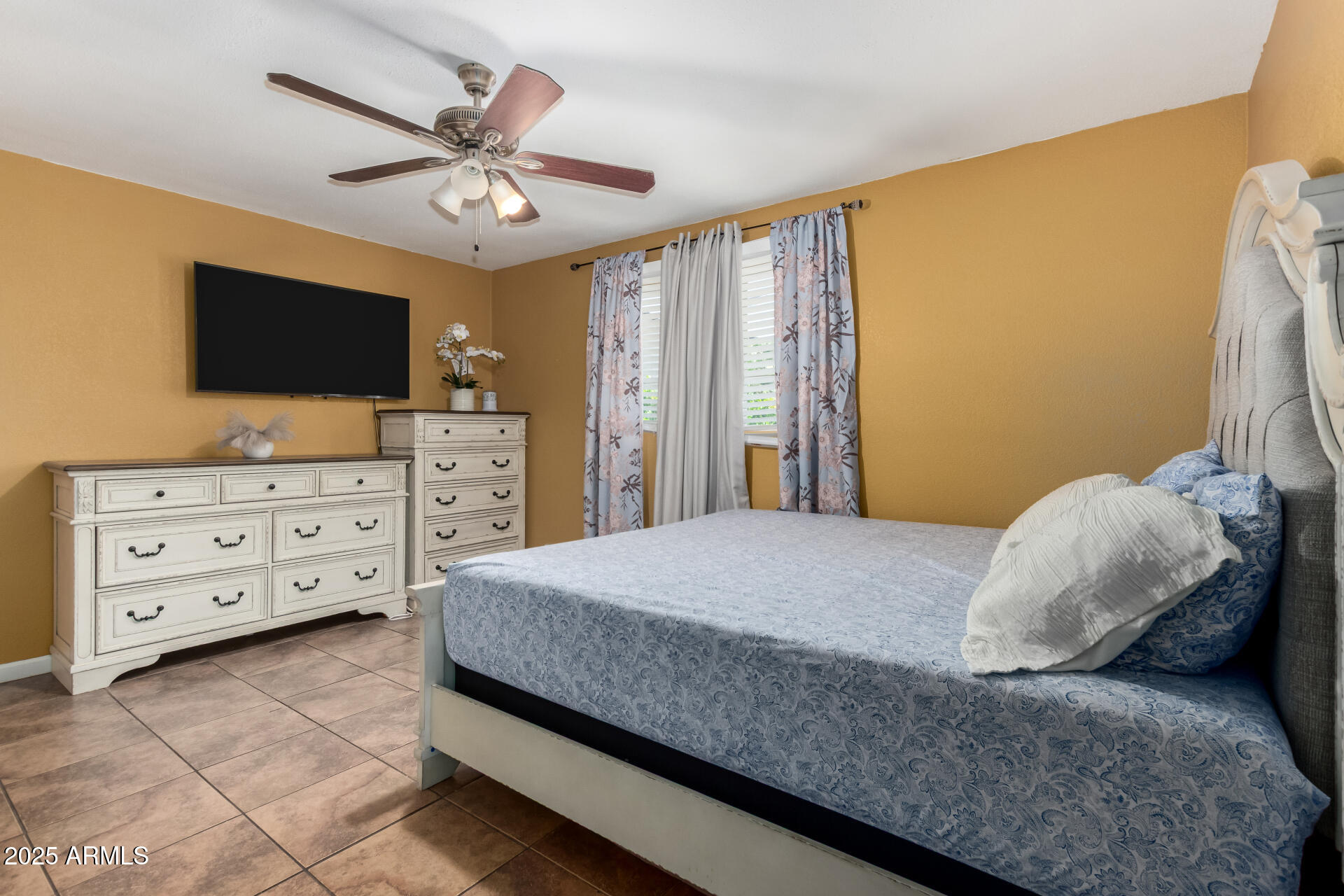 3152 North 24th Drive Phoenix, AZ 85015 - Photo 14 of 28 a bedroom with a bed and a flat screen tv