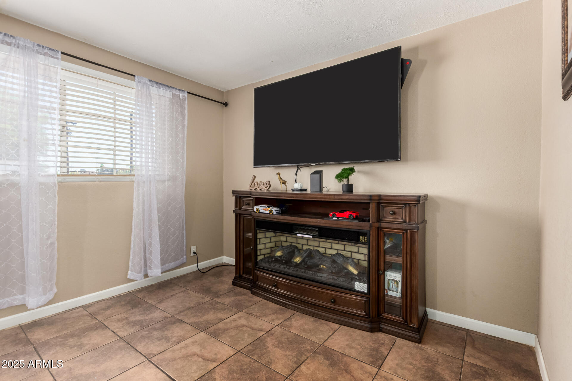 3152 North 24th Drive Phoenix, AZ 85015 - Photo 7 of 28 a living room with a flat screen tv and a fireplace