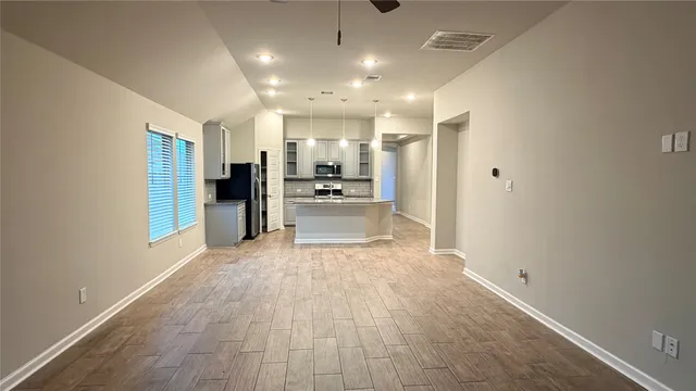 a view of kitchen with kitchen island white cabinets and stainless steel appliances