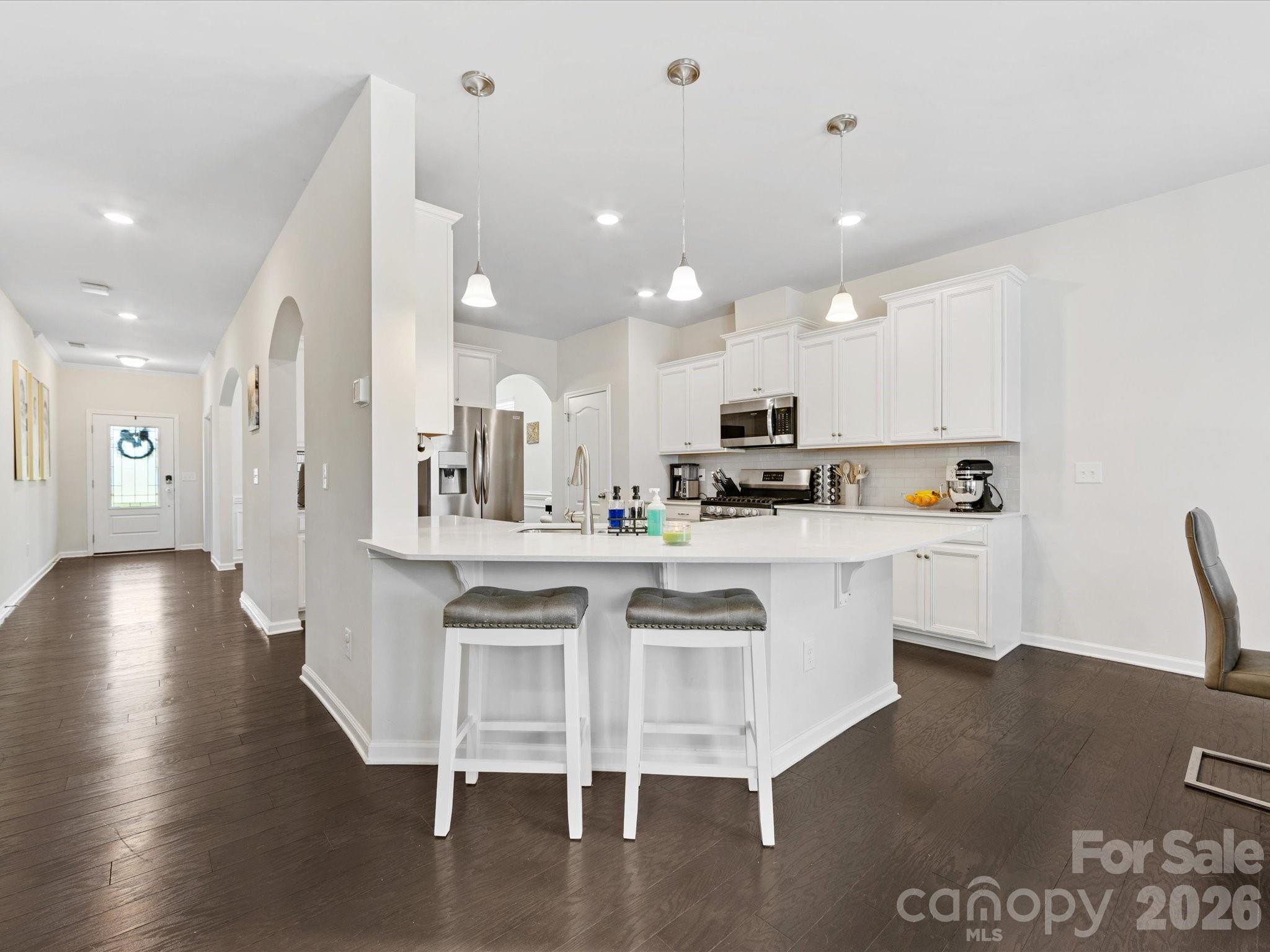 4261 Coachwhip Avenue Lancaster, SC 29720 - Photo 6 of 42 a kitchen with stainless steel appliances granite countertop a refrigerator a sink dishwasher a stove and a dining table with wooden floor