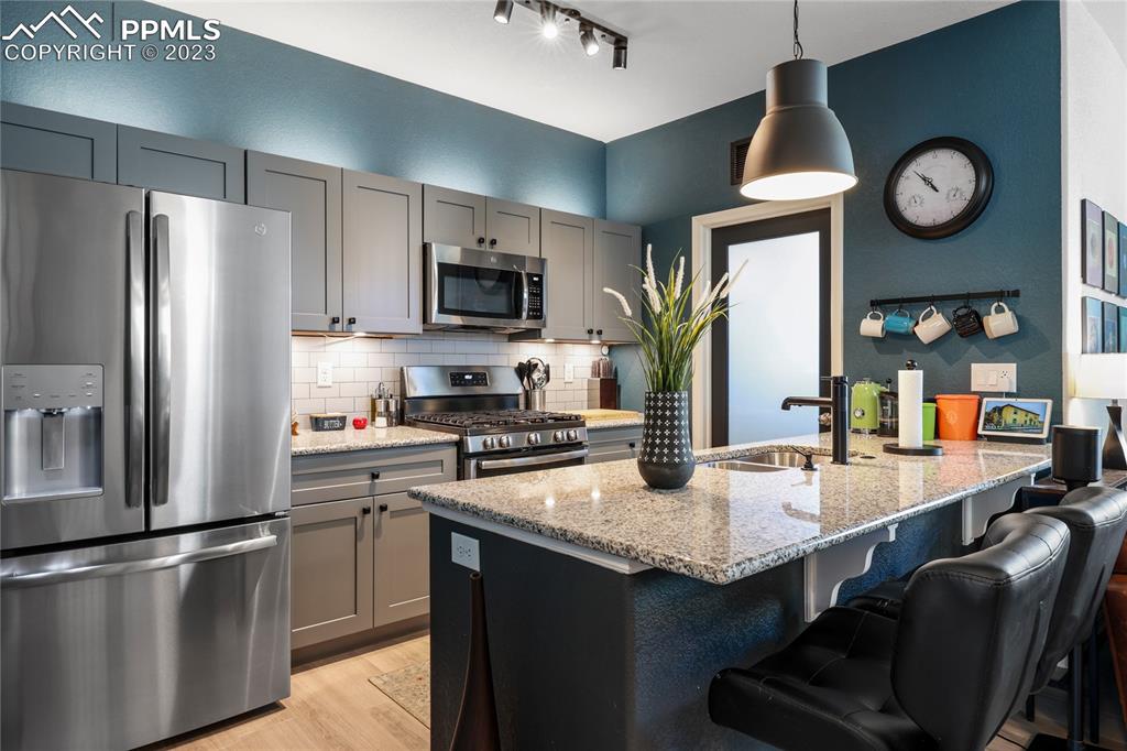 2016 Paddy Grove Colorado Springs, CO 80910 - Photo 11 of 39 a kitchen with stainless steel appliances granite countertop a stove refrigerator sink microwave and cabinets