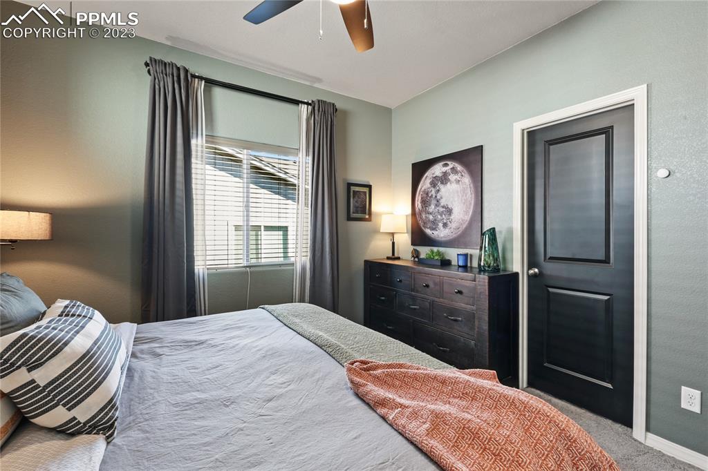 2016 Paddy Grove Colorado Springs, CO 80910 - Photo 23 of 39 a bedroom with a bed and a chandelier