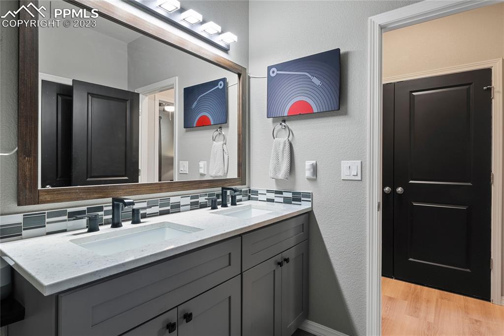 2016 Paddy Grove Colorado Springs, CO 80910 - Photo 24 of 39 a bathroom with a double vanity sink and a mirror
