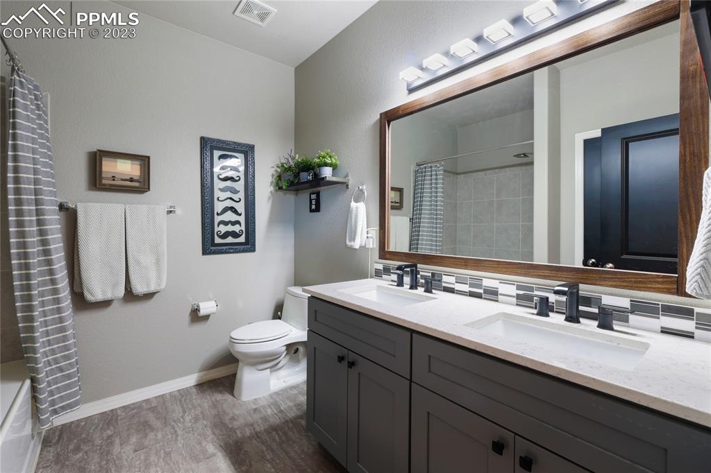 2016 Paddy Grove Colorado Springs, CO 80910 - Photo 25 of 39 a bathroom with a double vanity sink toilet and a mirror