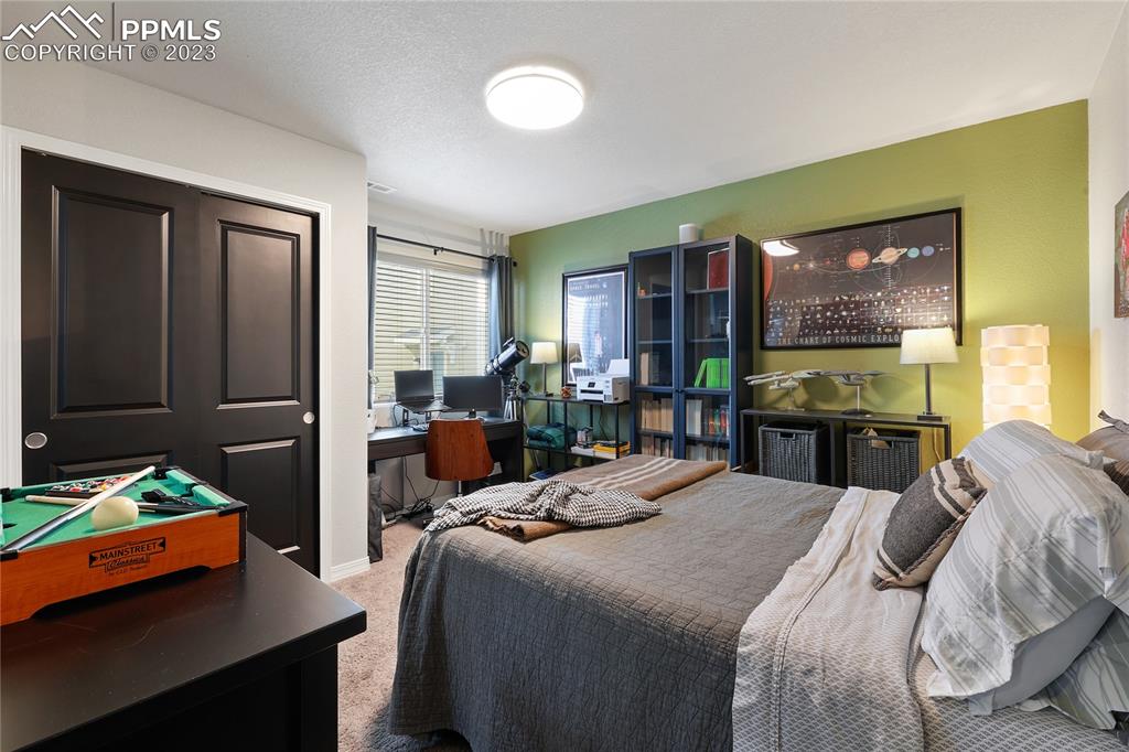 2016 Paddy Grove Colorado Springs, CO 80910 - Photo 28 of 39 a bedroom with a bed and wooden floor