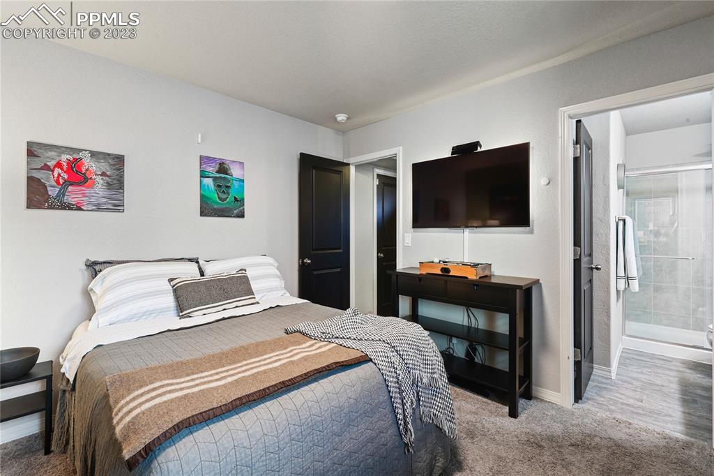 2016 Paddy Grove Colorado Springs, CO 80910 - Photo 29 of 39 a bedroom with a bed and a flat screen tv