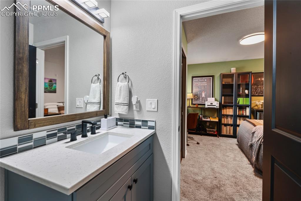 2016 Paddy Grove Colorado Springs, CO 80910 - Photo 30 of 39 a en suite bathroom with a sink and a mirror