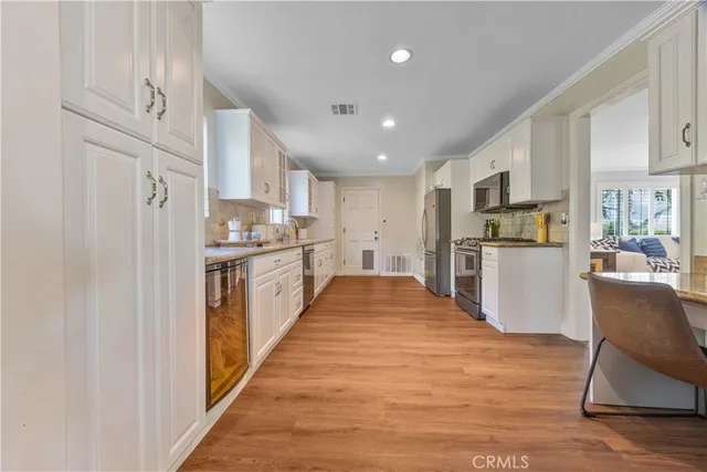 a large kitchen with stainless steel appliances kitchen island a large counter top and a refrigerator