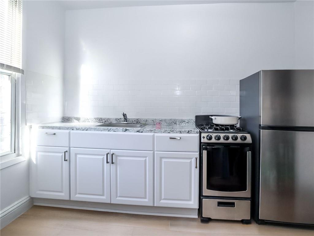 124 Hall Street Brooklyn, NY 11205 - Photo 16 of 31 a kitchen with granite countertop a refrigerator and a stove