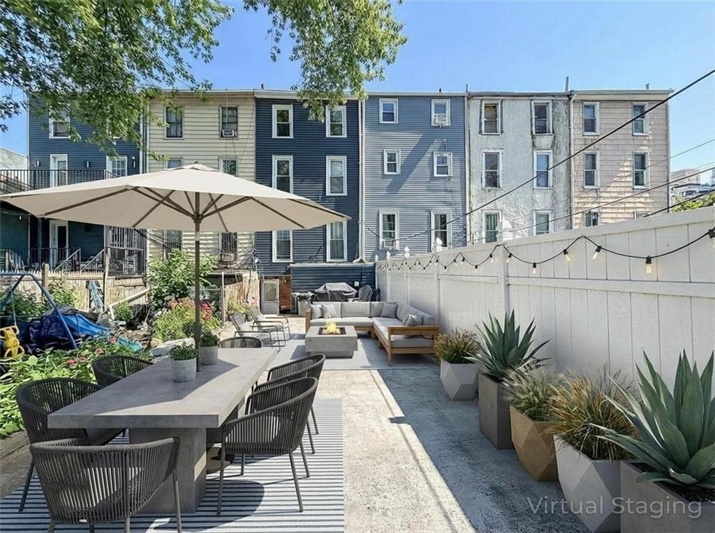 124 Hall Street Brooklyn, NY 11205 - Photo 26 of 31 a view of a patio with table and chairs under an umbrella