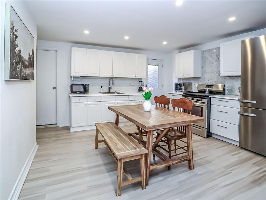 124 Hall Street Brooklyn, NY 11205 - Photo 7 of 31 a kitchen with a table chairs refrigerator and cabinets