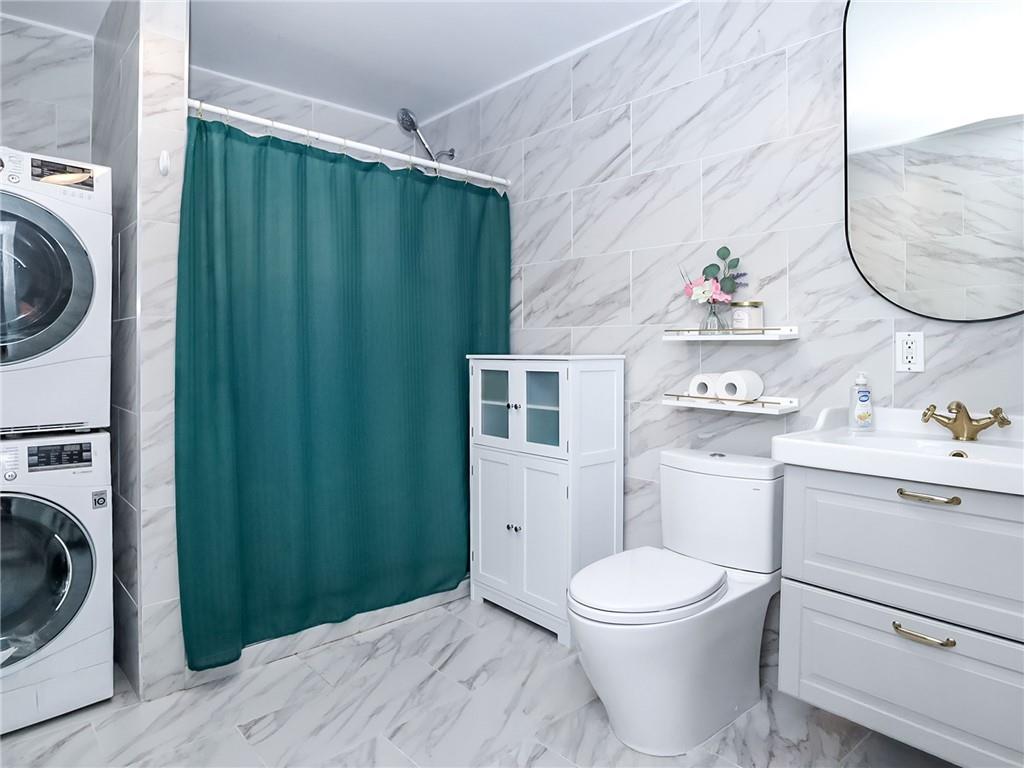 124 Hall Street Brooklyn, NY 11205 - Photo 8 of 31 a bathroom with a sink a toilet and a mirror