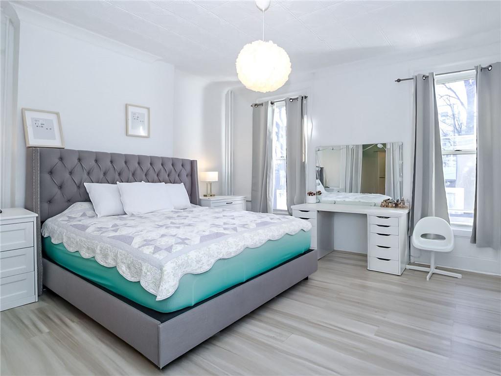 124 Hall Street Brooklyn, NY 11205 - Photo 9 of 31 a bedroom with a bed a chandelier and mirror