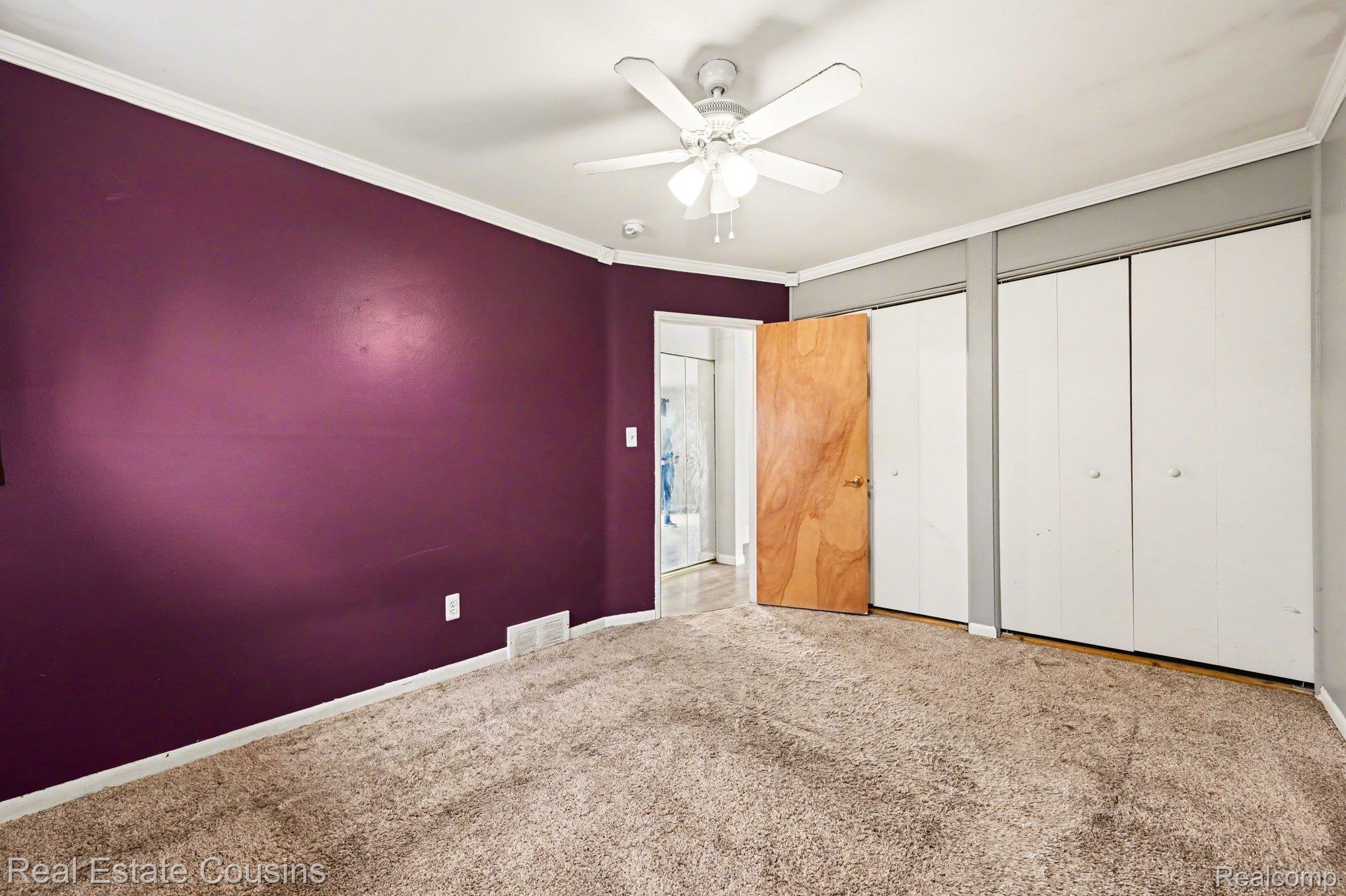 32224 Joy Road Livonia, MI 48150 - Photo 16 of 33 Unfurnished bedroom with ornamental molding, multiple closets, carpet flooring, and ceiling fan