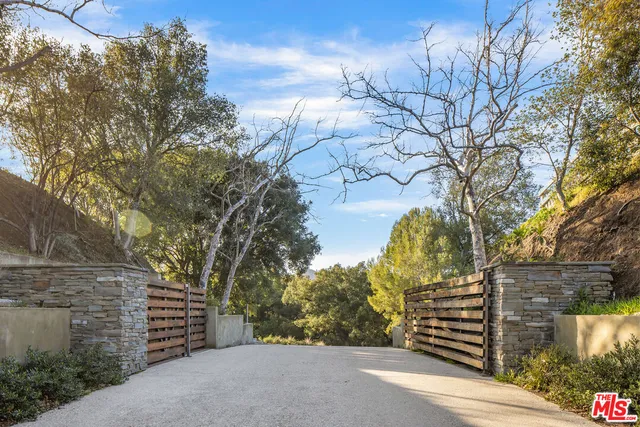 a pathway of a house and trees in the background
