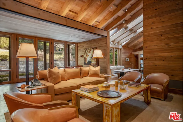 a living room with furniture and floor to ceiling windows