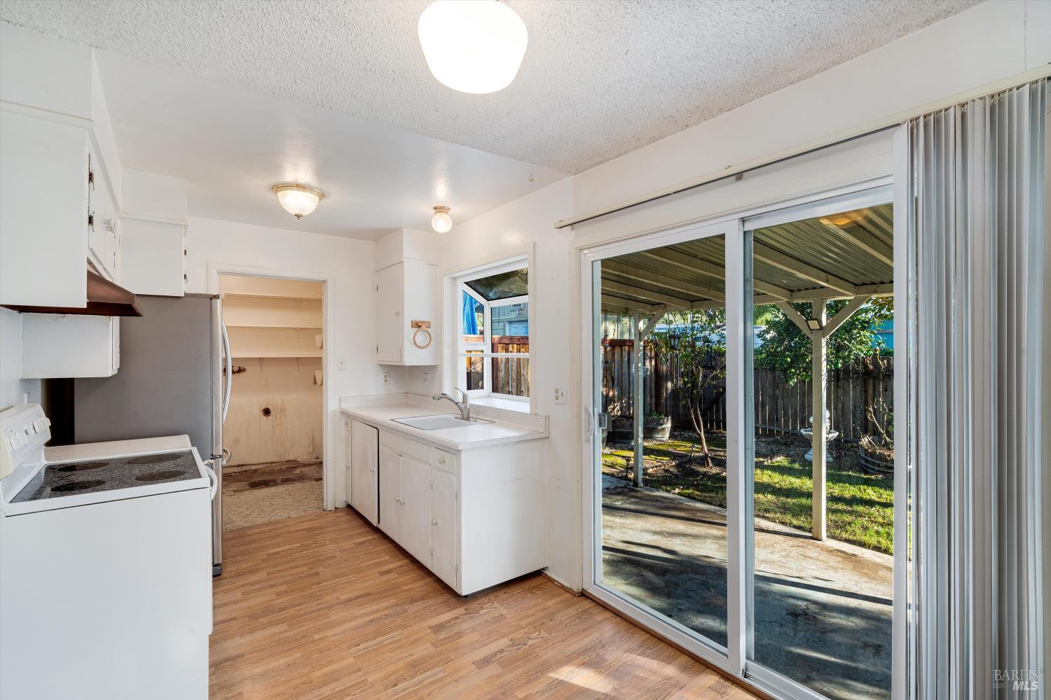 5158 Parkhurst Drive Santa Rosa, CA 95409 - Photo 13 of 40 a kitchen with white cabinets and a stove