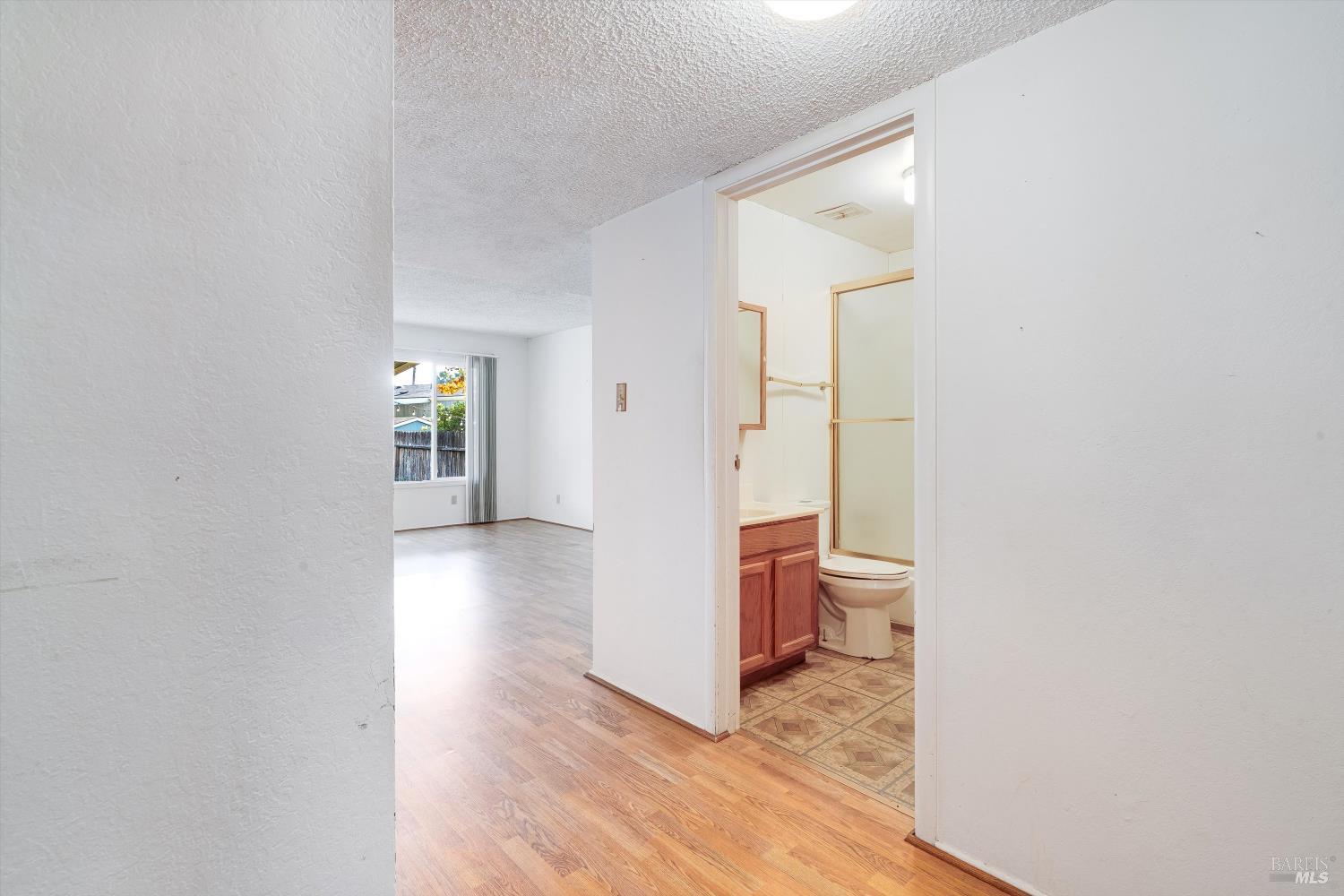 5158 Parkhurst Drive Santa Rosa, CA 95409 - Photo 2 of 40 a view of a hallway with wooden floor and a bathroom