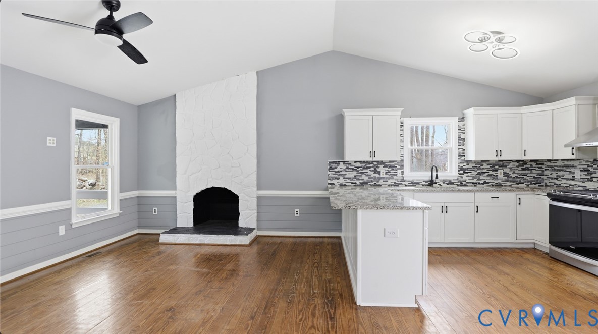 3063 Three Chopt Road Gum Spring, VA 23065 - Photo 18 of 45 a kitchen with granite countertop a stove a sink and white cabinets with wooden floor