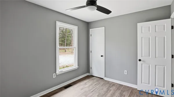 a view of empty room with window and ceiling fan