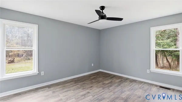 a view of empty room with wooden floor